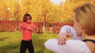 女子<strong>体育训练</strong>普拉提在秋季公园锻炼。 健身妇女在户外课堂上练习瑜伽体式。 灵活灵活